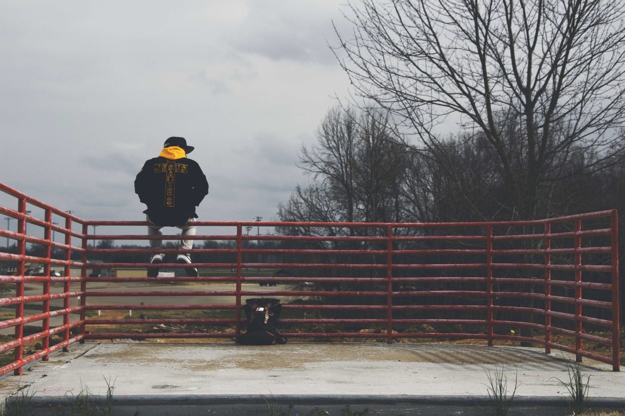 Male sitting on a fence