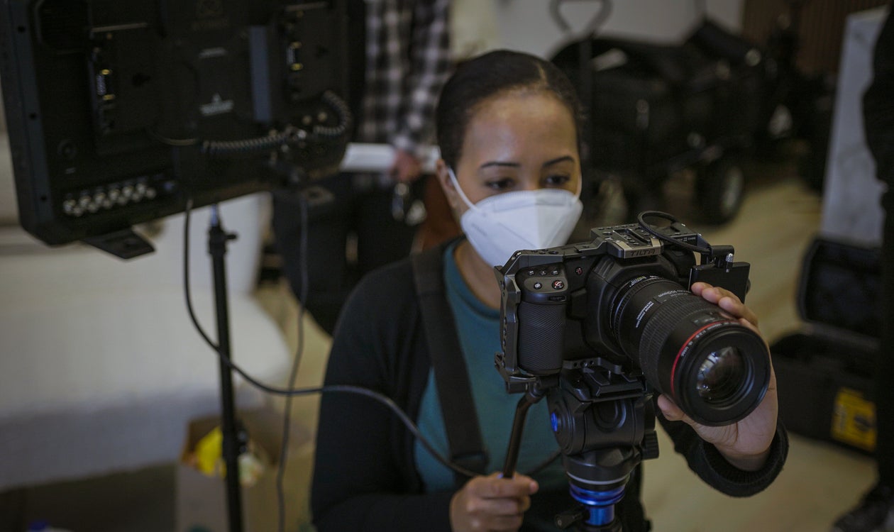 Camerawoman holding a camera behind the scene