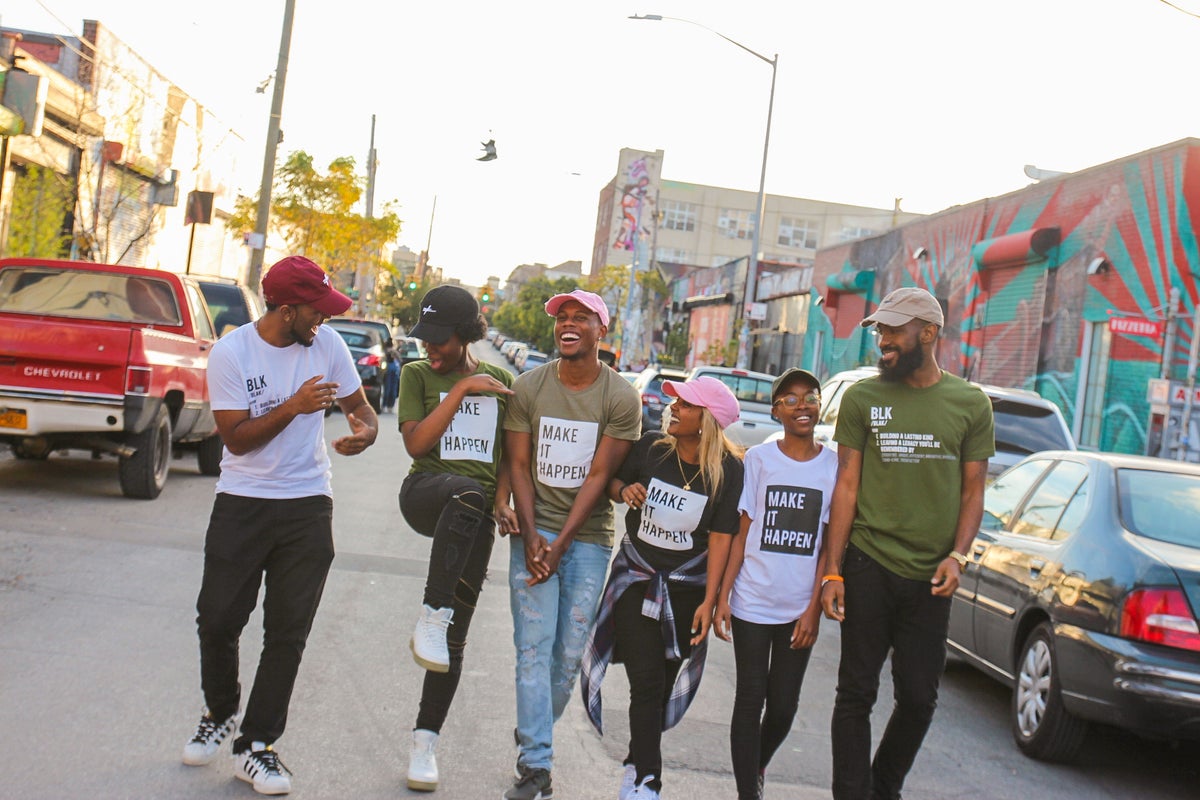 A group of Black friends walking and laughing together in their community