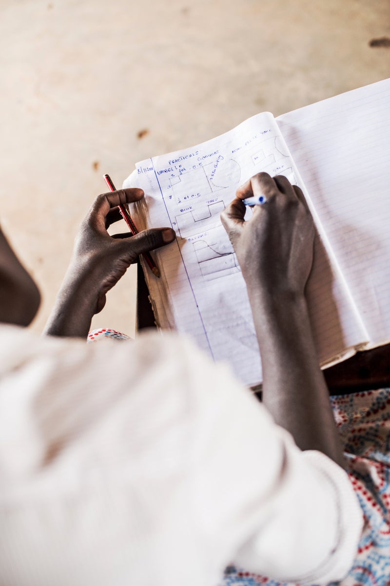 Hands writing notes — financial and administrative work