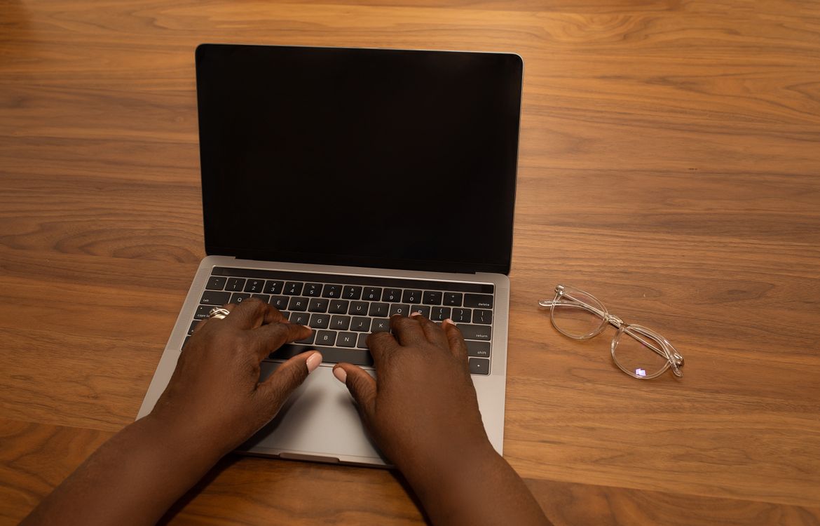 Hands typing on laptop