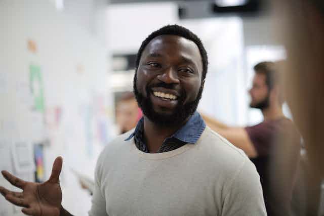 Black man smiling into camera working