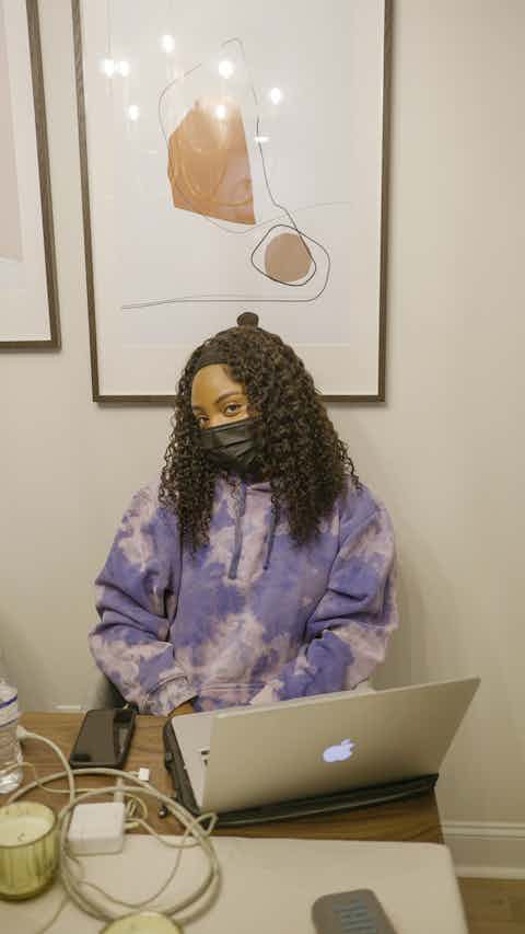 Black Woman with Jacket working in a laptop