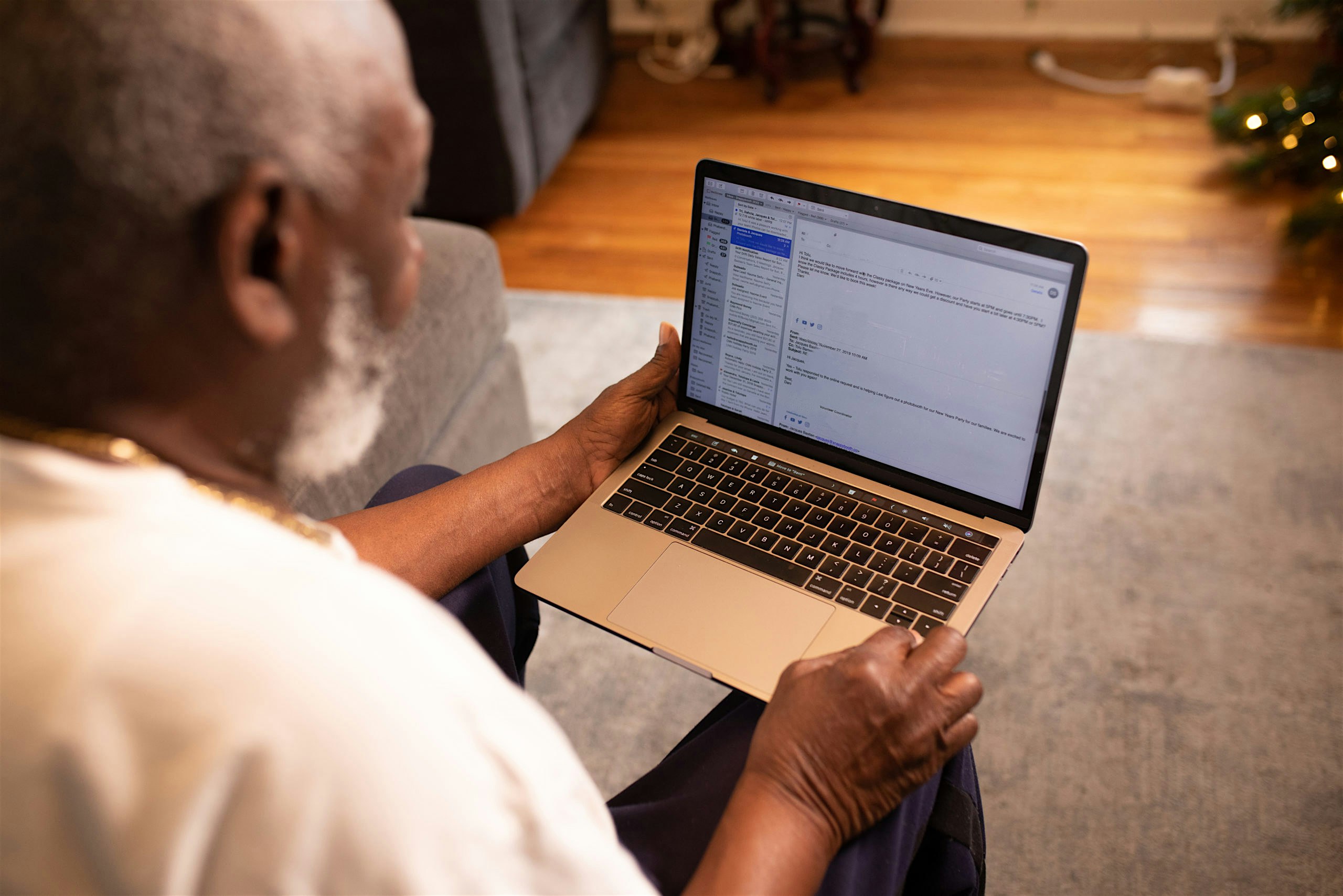 image of an older Black person with grey hair and beard viewing a laptop
