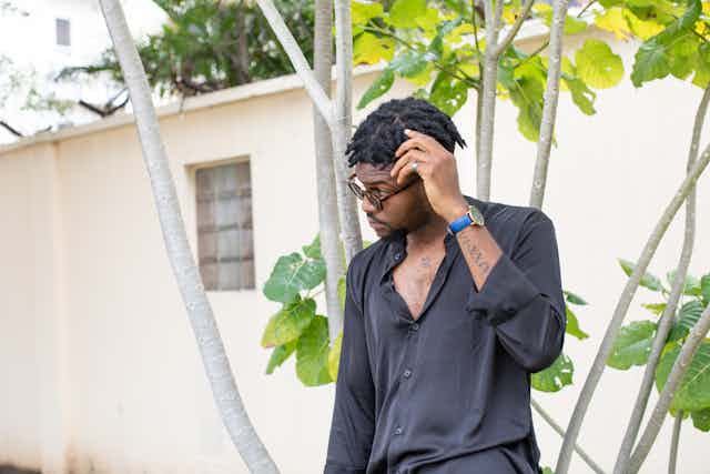 Man leaning on tree