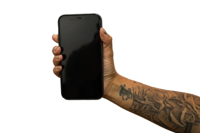 Right hand with tattooed forearm holds phone