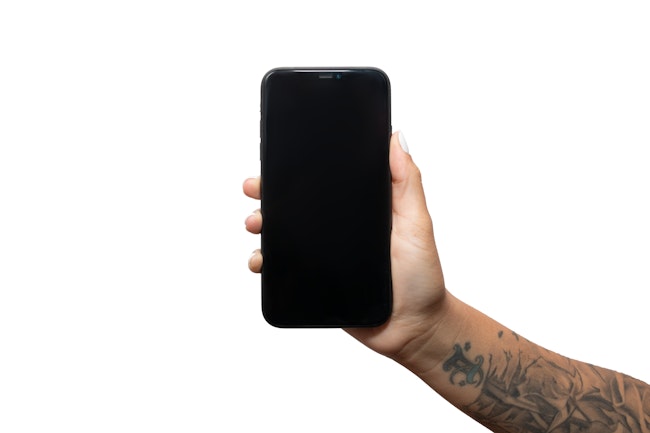 Hand with tattooed arm holding phone