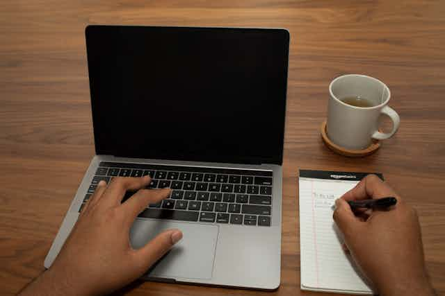 Hands typing on laptop