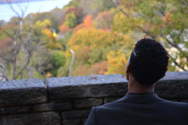 Black male starring at autumn trees