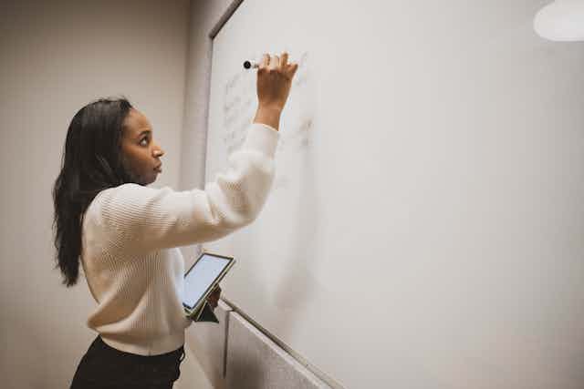 Woman writing on a whiteboard