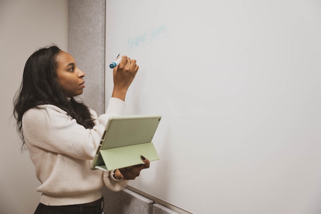 Woman Using Tablet at Whiteboard