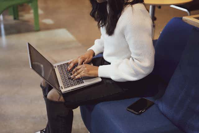 Office Scene: Woman Typing on Her Laptop