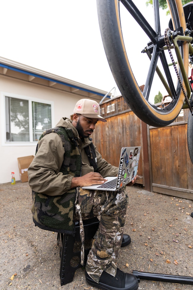 Man Performs Bike Diagnostics with Laptop