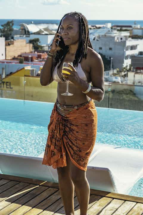 Woman Enjoying a Drink by the Pool