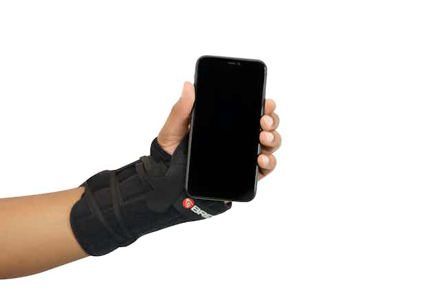 Person with a hand splint holding a phone