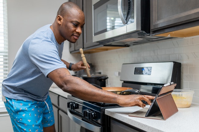 Man Cooks at Home with Tablet Recipe Guide