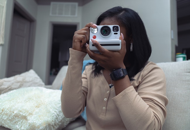 Woman holding a instant camera up to her face