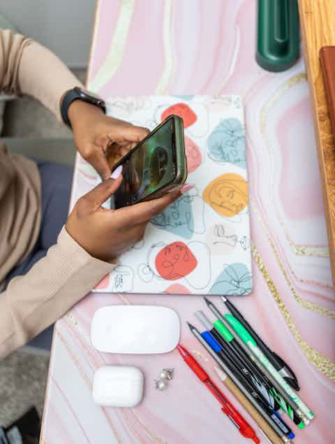 Close-Up: Woman on Smartphone at Desk