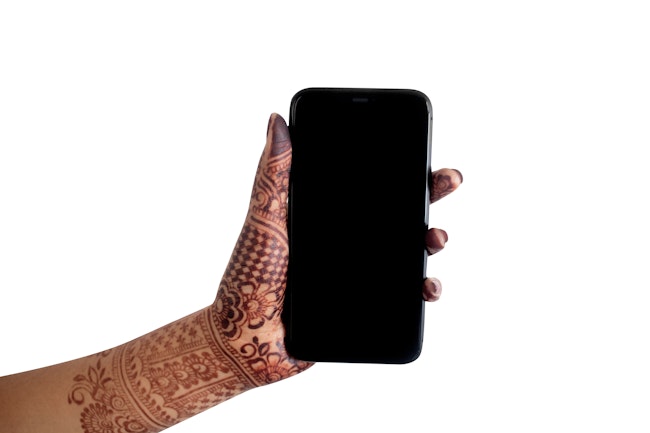 Person with henna tattoos, holding a phone